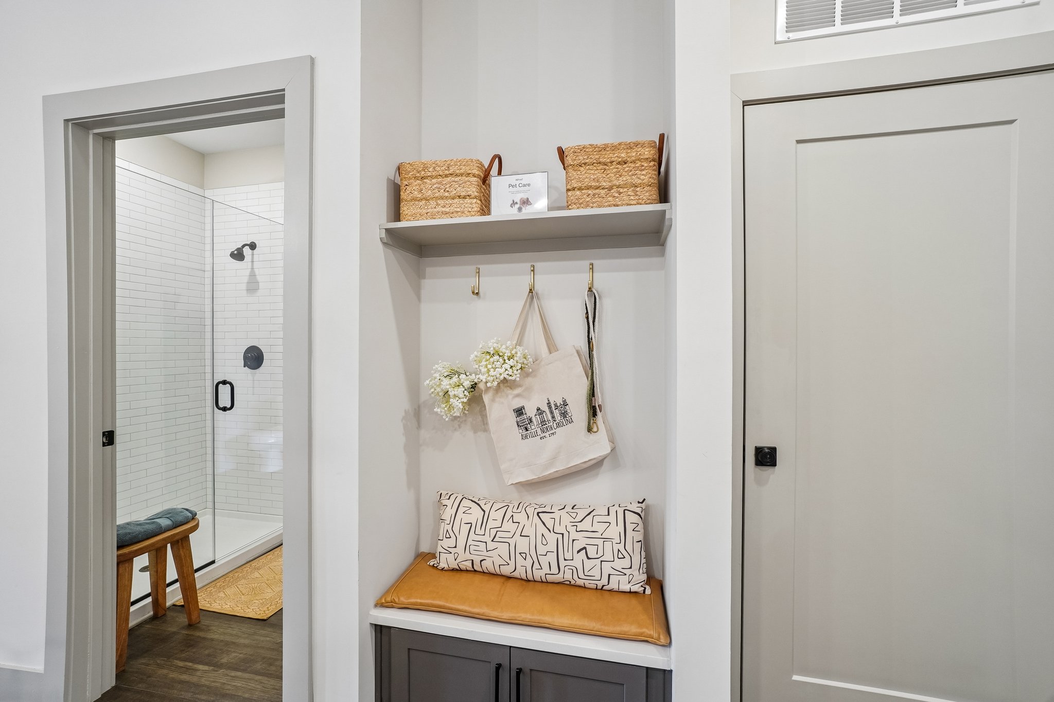 Bench and storage in the entryway of a model apartment at The Avery