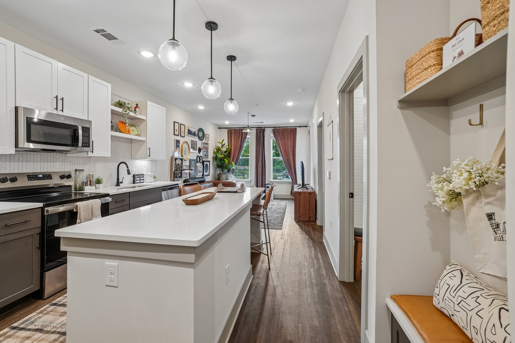 Entryway bench seat and luxury kitchen of a model apartment at The Avery