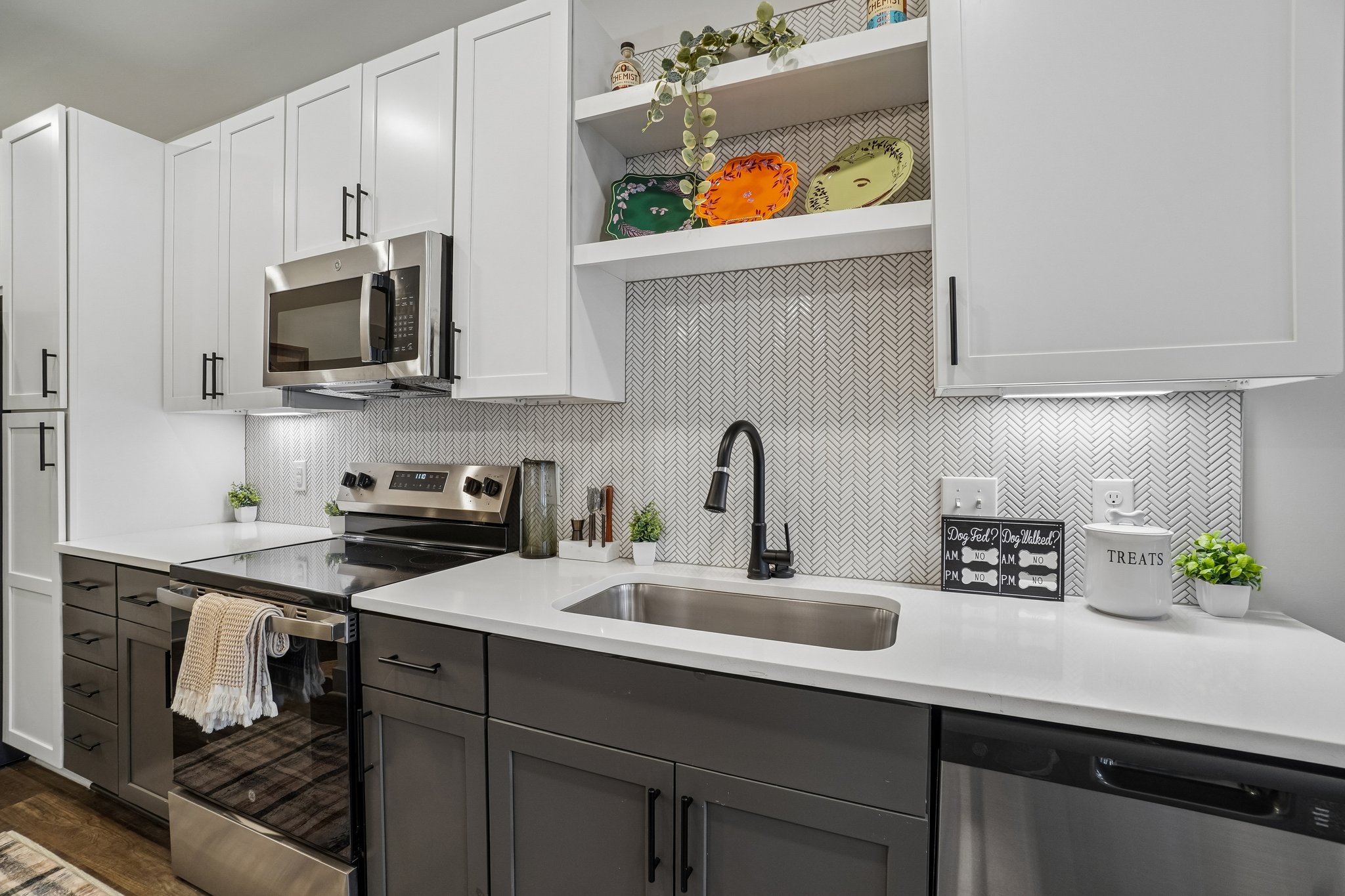 Kitchen with gooseneck faucet, stainless steel sink, and tile backsplash