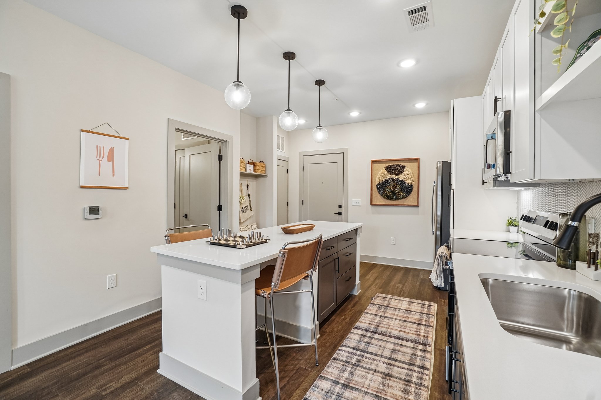 Model kitchen with island and pendant lighting at The Avery