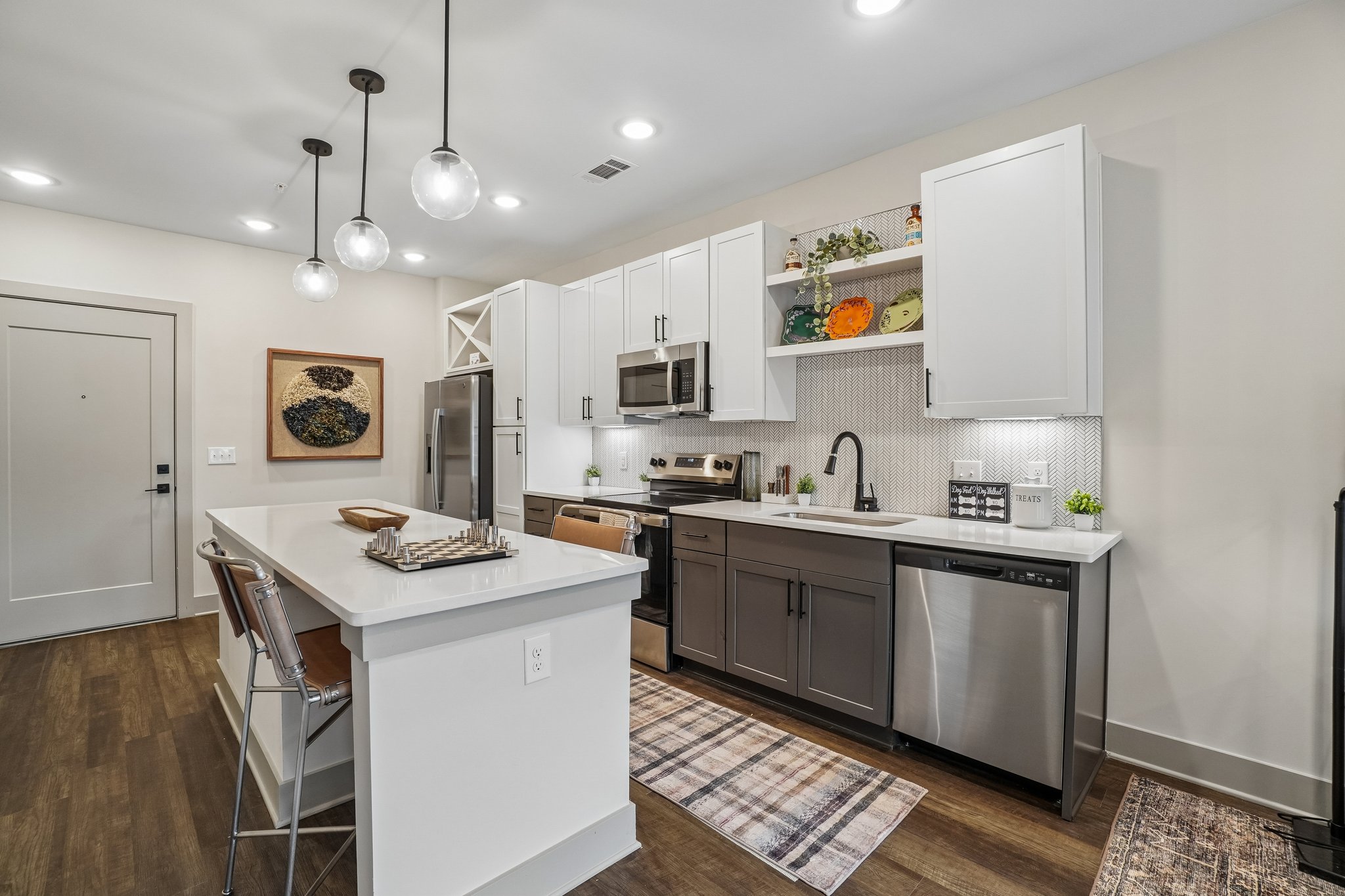 Model kitchen with island seating, pendant lighting, and quart countertops
