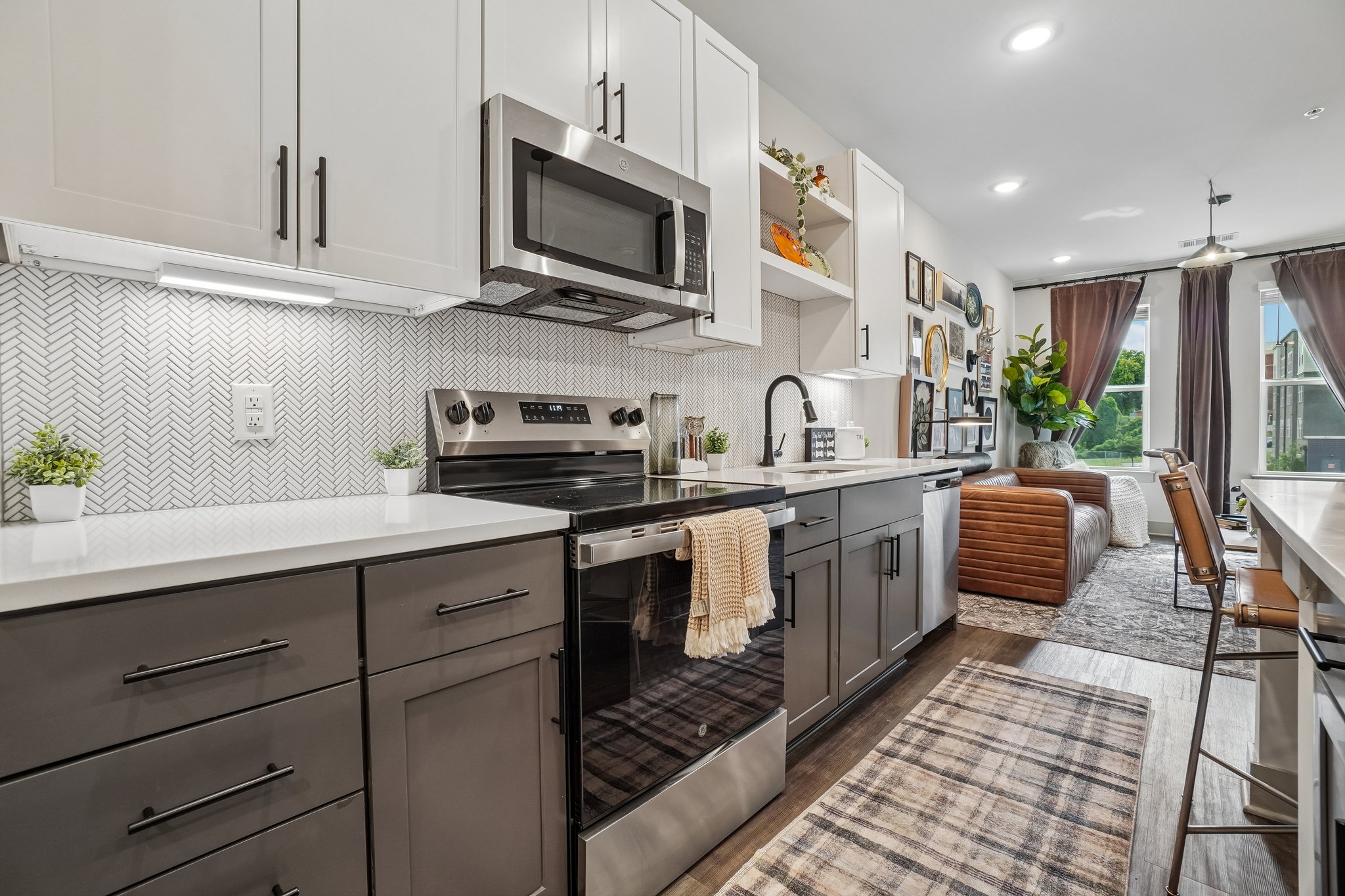Model kitchen with tile backsplash and quartz countertops at The Avery