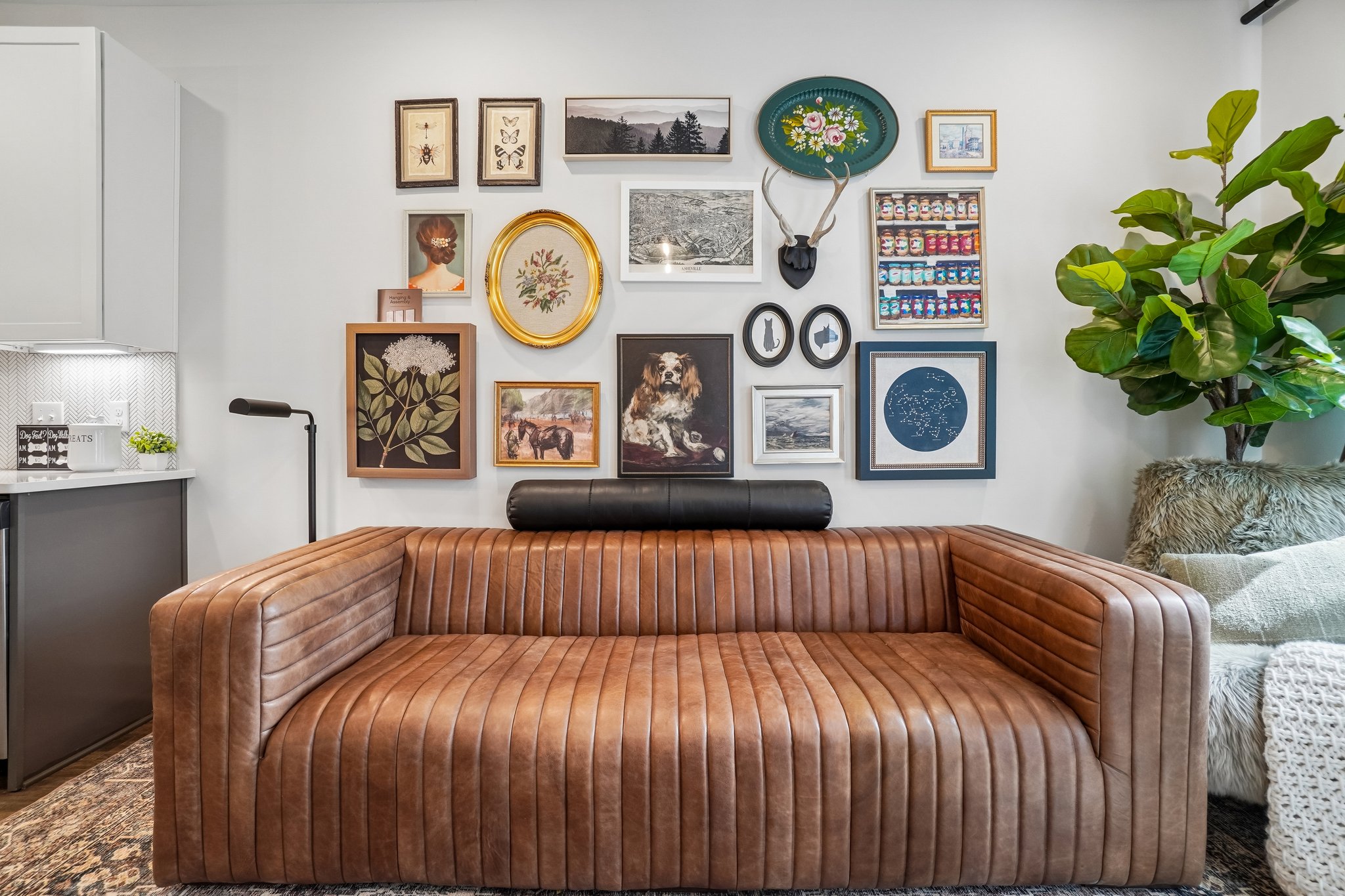 Model living room with leather sofa and gallery wall