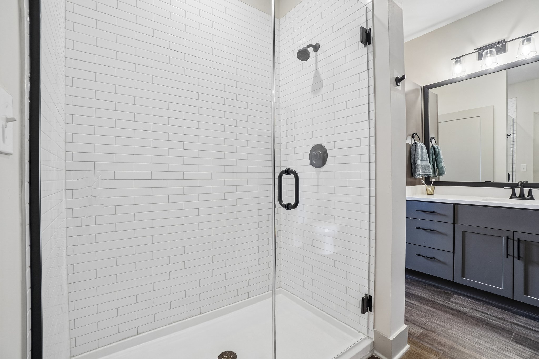 Tile surround walk-in shower in a model bathroom at The Avery